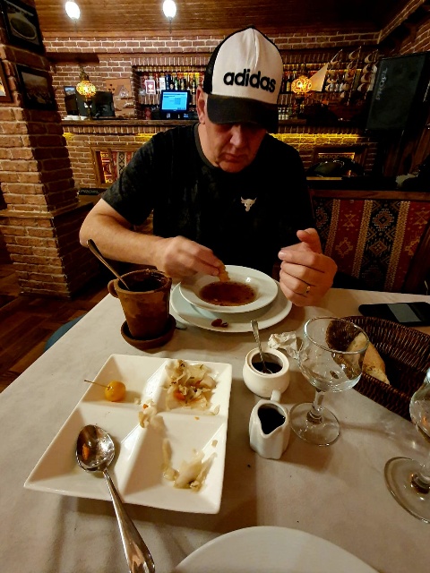 Marius Grobbelaar dining at a traditional restaurant in Sheki, enjoying piti served in its characteristic individual clay pot