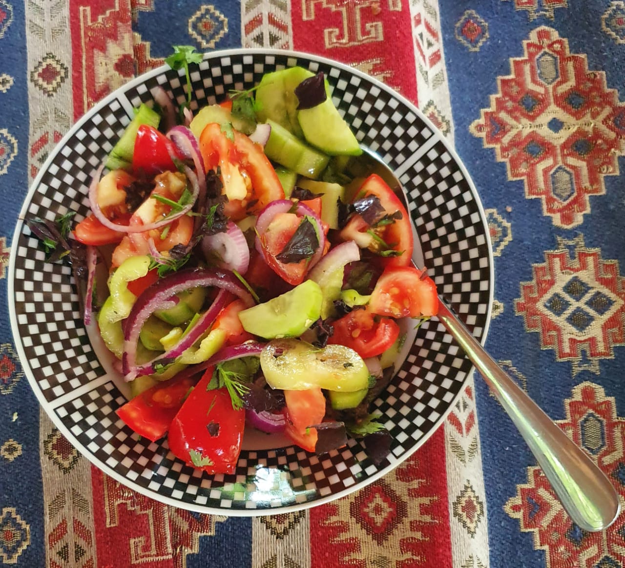 A bowl of fresh Azerbaijani salad featuring sliced tomatoes and cucumbers, representing the simple, fresh vegetable-based side dishes commonly served with traditional meals