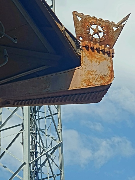 Distinctive ornamental roof decoration on a traditional village building in Zaqatala, Azerbaijan, featuring decorative metalwork with a scalloped edge and star motif