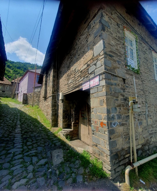 A traditional 200-year-old stone house in İlisu village, Azerbaijan, featuring characteristic mountain architecture with cobblestone path