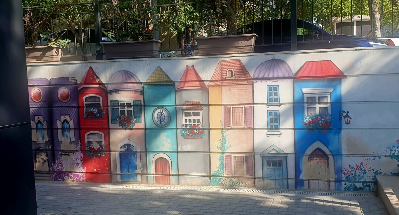 A colorful mural in Baku depicting a row of whimsical houses with different architectural styles and vibrant colors