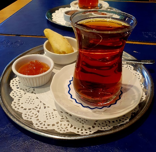 Traditional tea service in an Azerbaijani tea house, showing tea in armudu glasses accompanied by preserves, sweets, and other traditional accompaniments on a serving tray