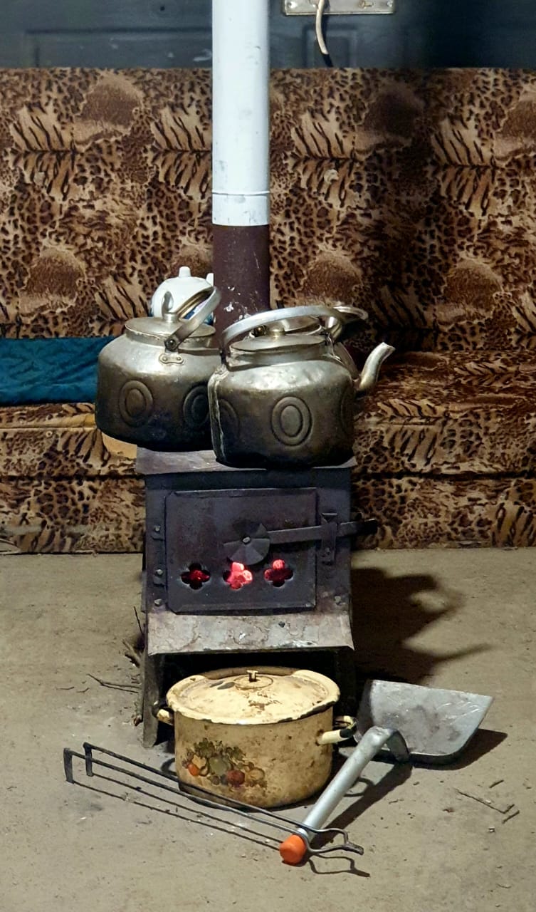 A traditional wooden stove being used to boil water for tea in Azerbaijan, showing the enduring use of wood-fired cooking methods