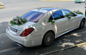 A decorated Mercedes wedding car in Azerbaijan, adorned with ribbons and flowers for a traditional wedding celebration